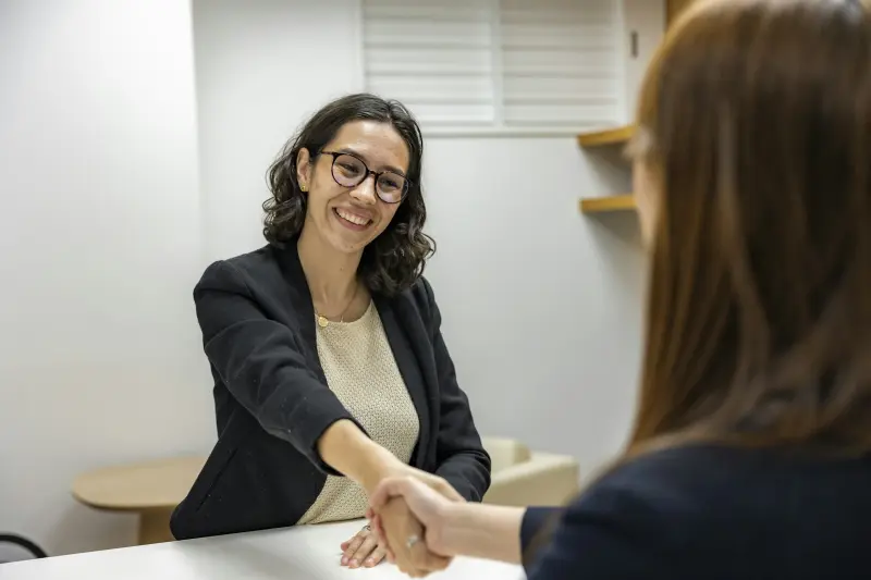 Erfolgreiches Vermittlungsgespräch im Büro — Handschlag über den Tisch